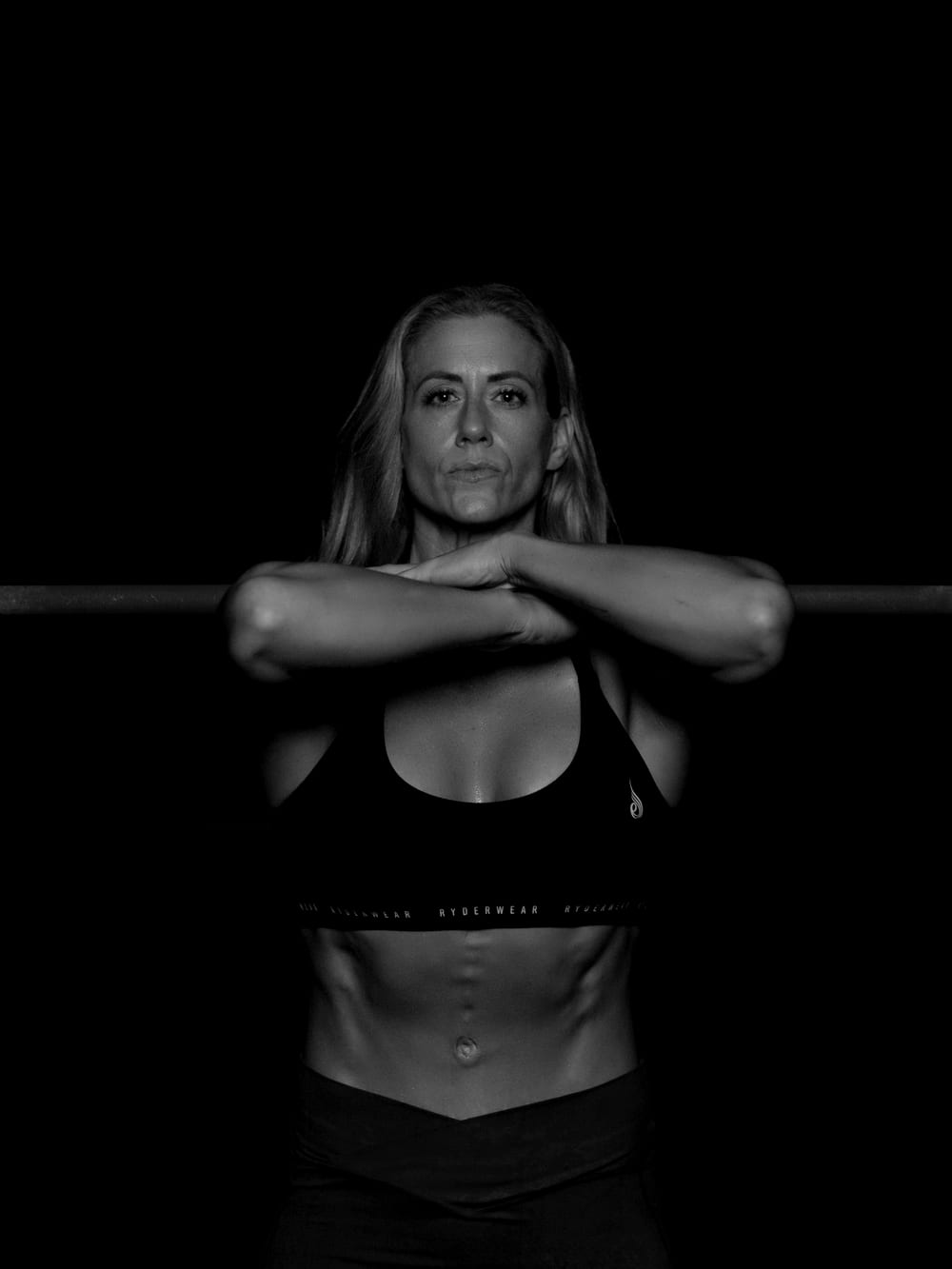 Nora Vecci in a darkened gym under a single directional light.